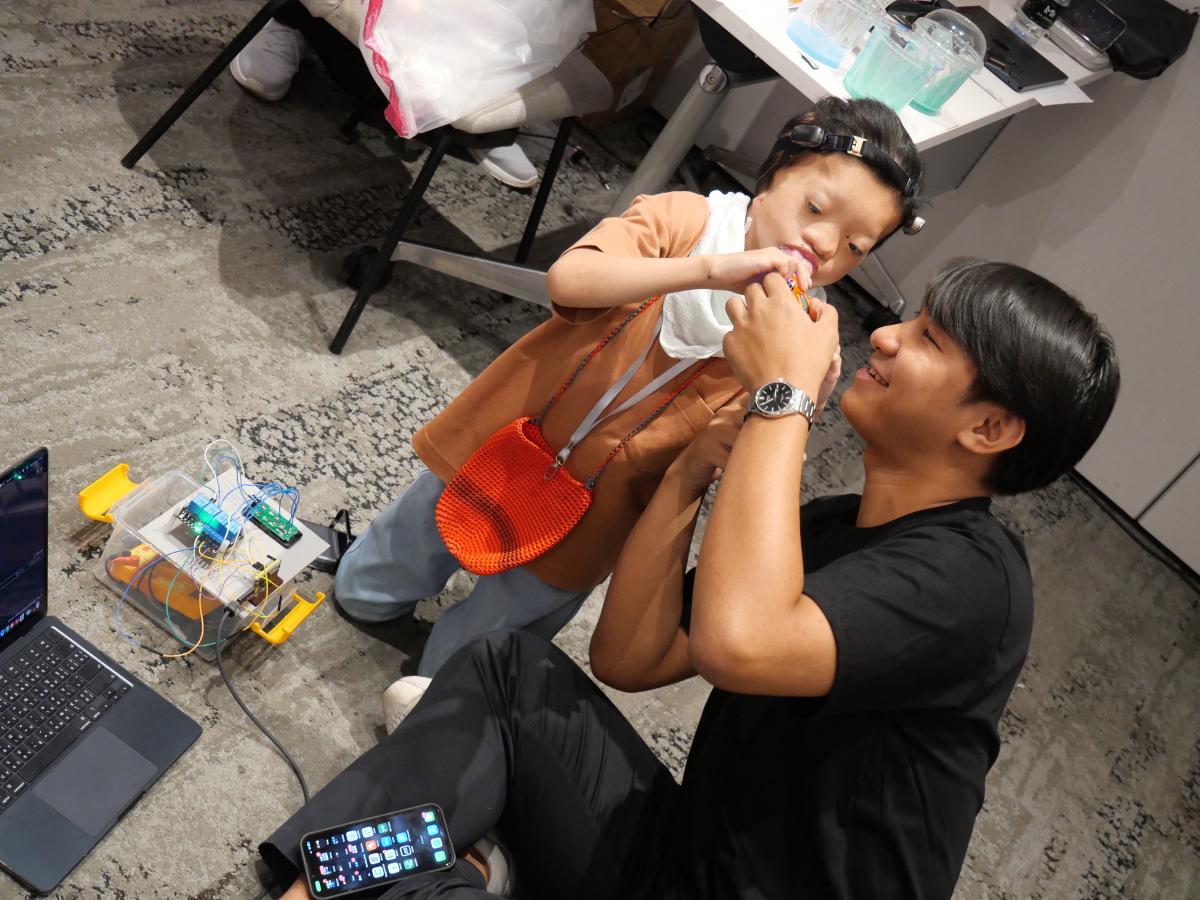 Child and mentor working on robotics at Sentient Minds Camp